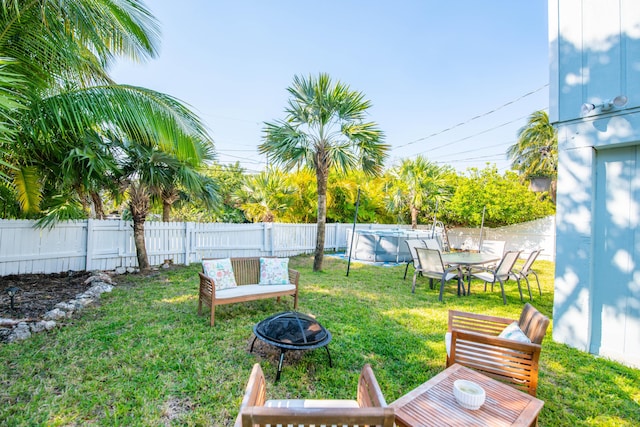 view of yard with a fenced in pool, a fenced backyard, and an outdoor fire pit