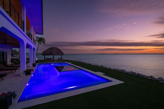 pool at dusk with a gazebo and a water view