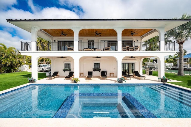 rear view of property with ceiling fan, a patio, and a balcony