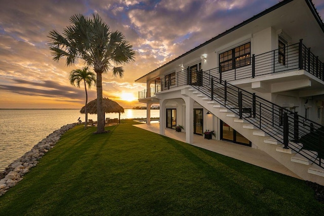 exterior space with a patio, a balcony, a yard, a gazebo, and a water view