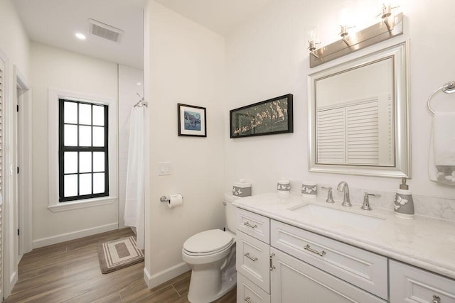 bathroom featuring hardwood / wood-style flooring, vanity, curtained shower, and toilet