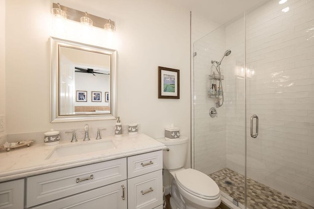 bathroom featuring vanity, an enclosed shower, and toilet