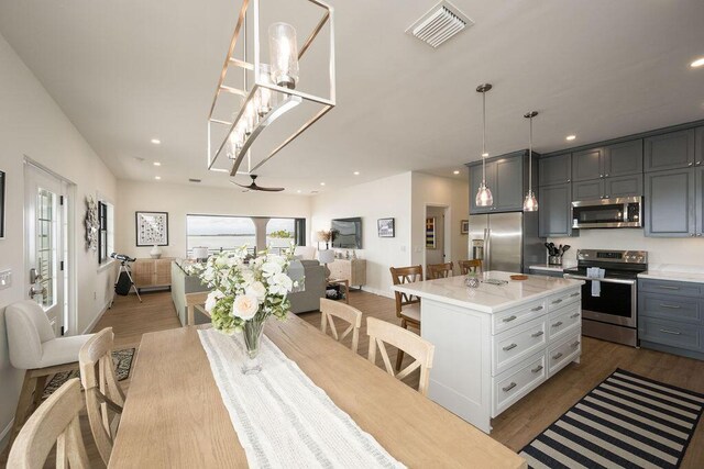 dining space with ceiling fan and wood-type flooring