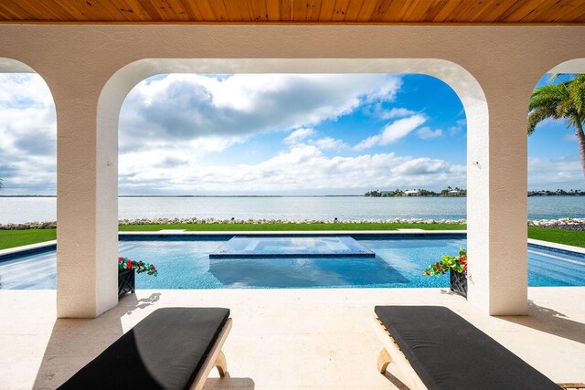 view of pool with a water view and a patio area