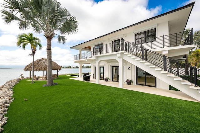 back of property with a water view, a gazebo, a balcony, and a patio