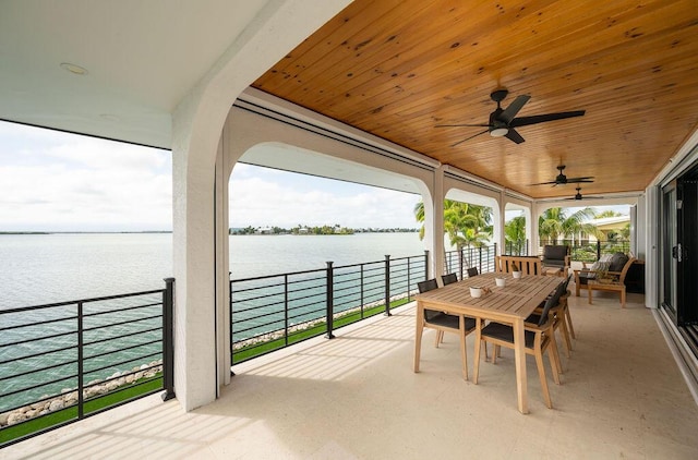 view of patio with ceiling fan and a water view