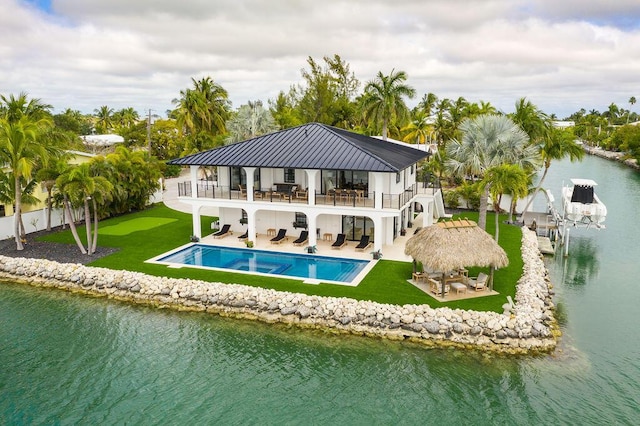 back of house featuring a balcony, a lawn, a gazebo, a water view, and a patio area