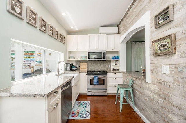 421 United St, Key West, FL 33040 - kitchen with sink, appliances with stainless steel finishes, a wall unit AC, light stone countertops, and white cabinets