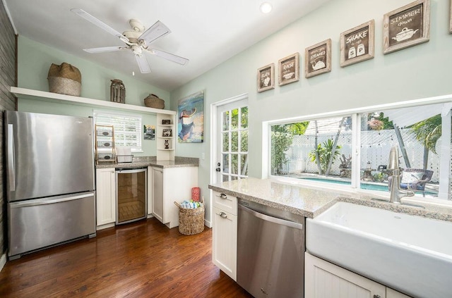 421 United St, Key West, FL 33040 - kitchen with appliances with stainless steel finishes, white cabinetry, sink, wine cooler, and light stone countertops