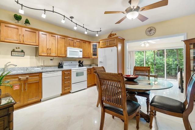 kitchen with ceiling fan, light stone countertops, sink, and white appliances