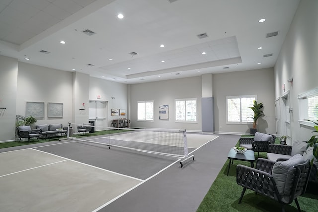 recreation room featuring a raised ceiling and a high ceiling