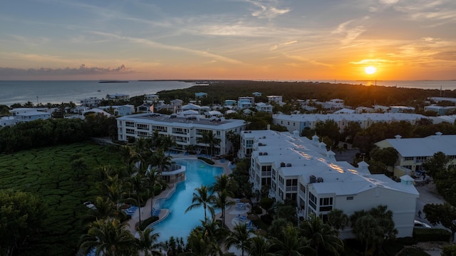 aerial view at dusk featuring a water view