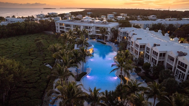 aerial view at dusk featuring a water view