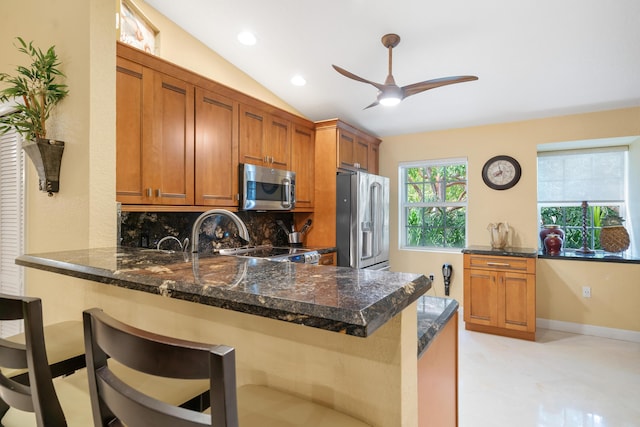 kitchen featuring decorative backsplash, a breakfast bar area, stainless steel appliances, and kitchen peninsula