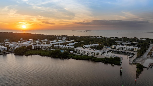 aerial view at dusk featuring a water view