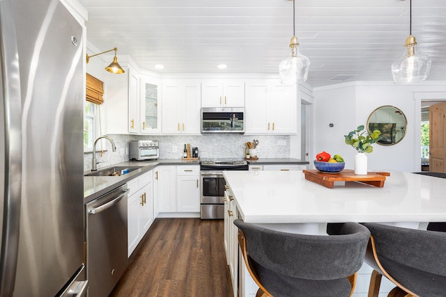 kitchen with a sink, stainless steel appliances, tasteful backsplash, and a breakfast bar area