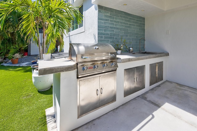 view of patio / terrace featuring a sink, exterior kitchen, and grilling area