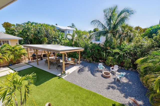 view of yard featuring a patio area, a fire pit, and fence