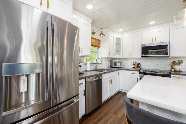 kitchen with a sink, white cabinets, dark wood-style floors, and stainless steel appliances