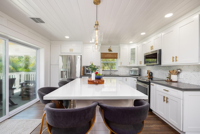 kitchen featuring a breakfast bar area, visible vents, tasteful backsplash, and appliances with stainless steel finishes