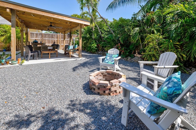 view of patio / terrace featuring ceiling fan, fence, and an outdoor fire pit