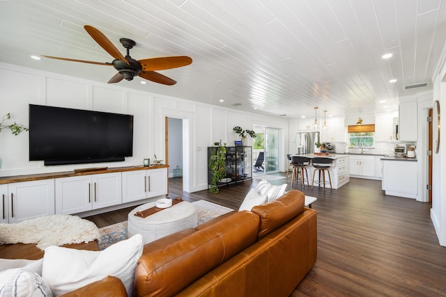 living room with a decorative wall, recessed lighting, dark wood-style floors, and ceiling fan