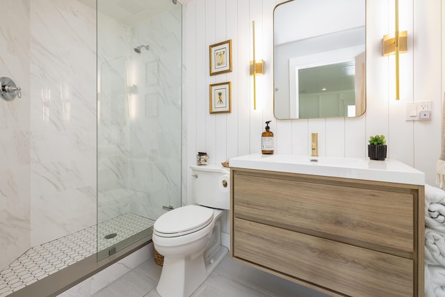 full bathroom featuring a marble finish shower, toilet, and vanity