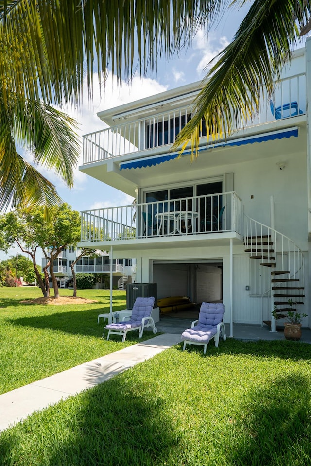 95 Coco Plum Dr Unit 1A, Marathon, FL 33050 - back of house featuring stairway, a balcony, a lawn, and an attached garage