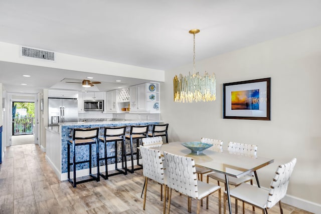 1133 W Ocean Dr Unit 4, Marathon, FL 33050 - dining room featuring light wood-style floors, a chandelier, baseboards, and ceiling fan