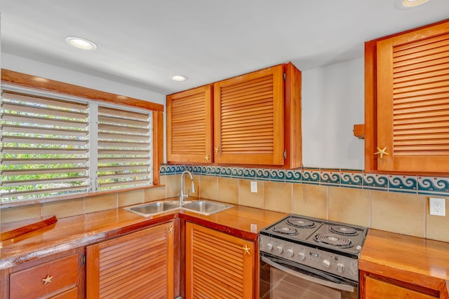 10 W Cook, Big Pine, FL 33043 - kitchen featuring brown cabinetry, decorative backsplash, a sink, recessed lighting, and electric stove