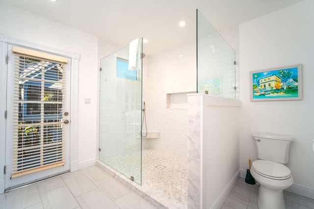 bathroom with tiled shower and toilet