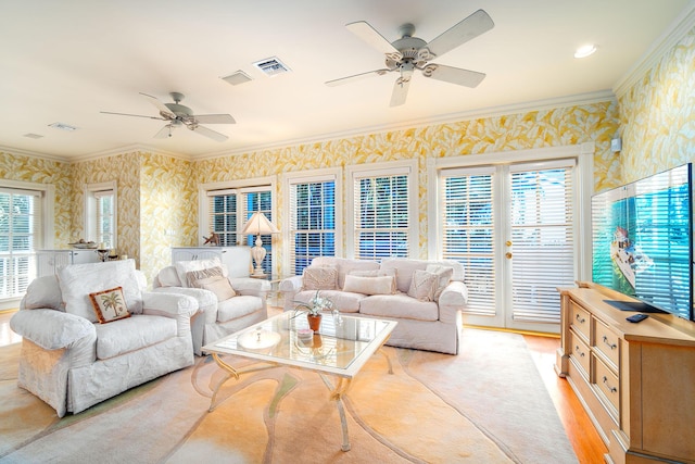 living room with light hardwood / wood-style flooring, ornamental molding, and ceiling fan