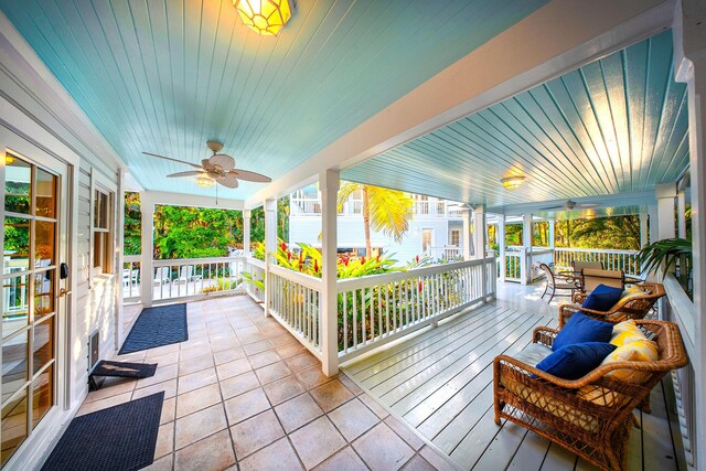 sunroom / solarium featuring wood ceiling, plenty of natural light, and ceiling fan