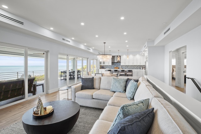 254 W Seaview Cir, Duck, FL 33050 - living room with recessed lighting, light wood-style flooring, and a water view
