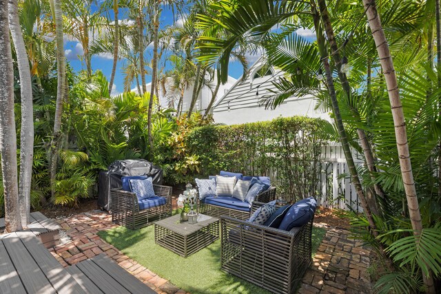 wooden terrace with an outdoor hangout area, a patio area, and fence