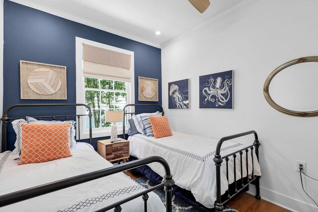 bedroom featuring crown molding, wood finished floors, baseboards, and a ceiling fan