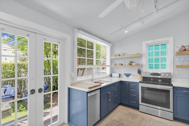 kitchen featuring open shelves, appliances with stainless steel finishes, and blue cabinets