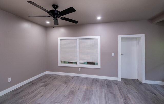 empty room with ceiling fan and light hardwood / wood-style floors