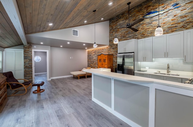 kitchen with white cabinetry, sink, decorative light fixtures, and stainless steel refrigerator with ice dispenser