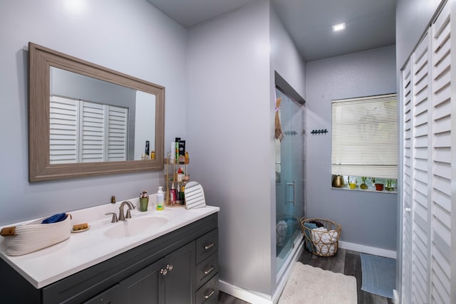 bathroom featuring a shower with door, vanity, and wood-type flooring