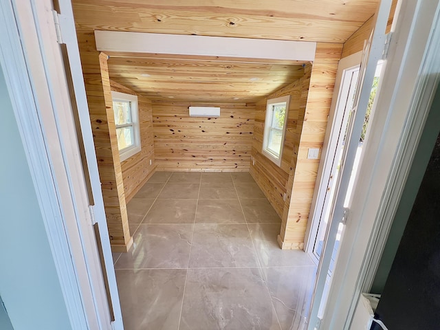 interior space featuring light tile patterned flooring, wooden ceiling, and wood walls