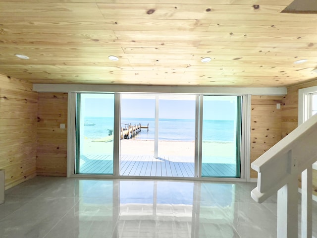 interior space featuring a view of the beach, wooden walls, and wooden ceiling