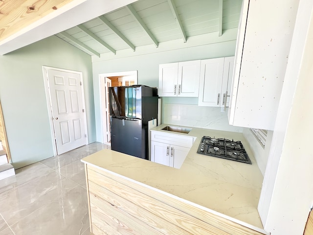 kitchen with white cabinets, kitchen peninsula, lofted ceiling with beams, and black appliances