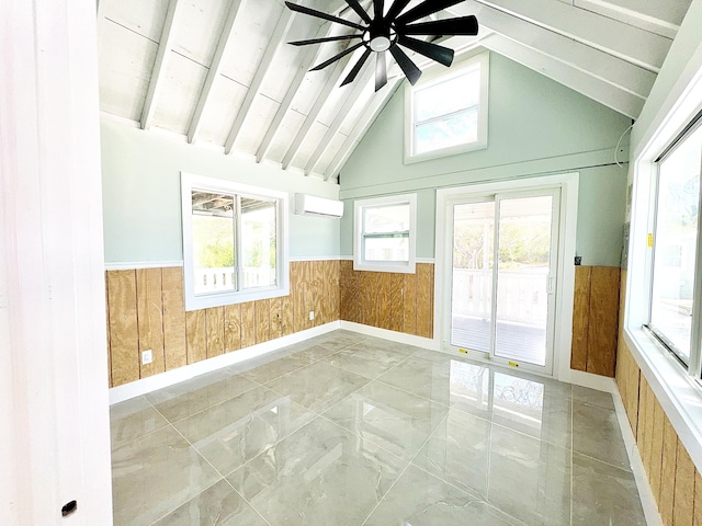 unfurnished sunroom with a healthy amount of sunlight, ceiling fan, lofted ceiling with beams, and a wall mounted AC