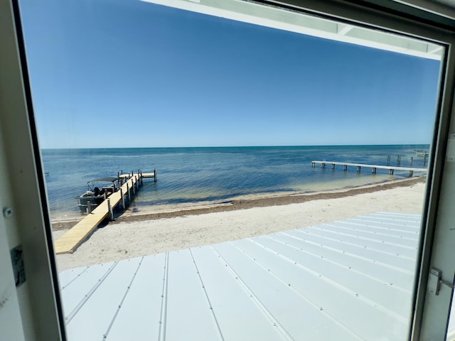 dock area with a water view and a beach view