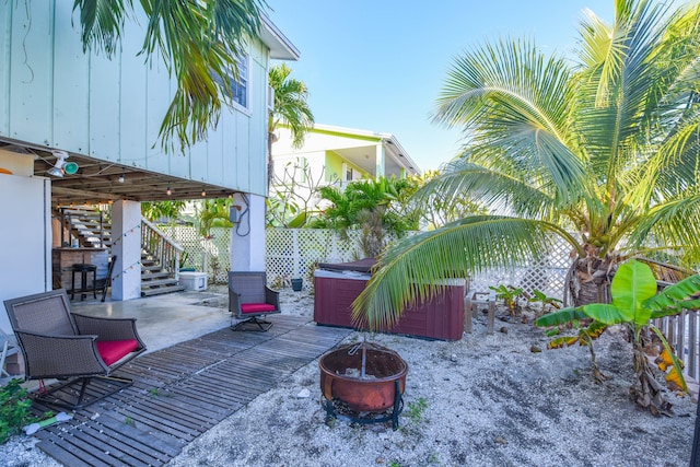 view of patio with a hot tub and an outdoor fire pit