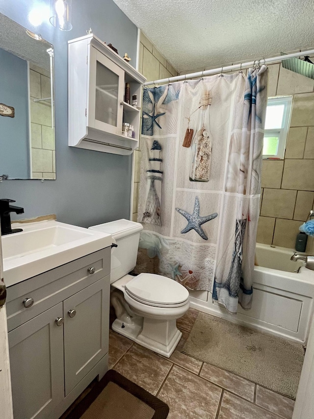 full bathroom with tile patterned flooring, vanity, a textured ceiling, toilet, and shower / bath combo with shower curtain