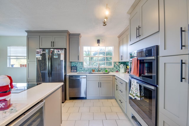 kitchen featuring sink, gray cabinetry, wine cooler, decorative backsplash, and stainless steel appliances