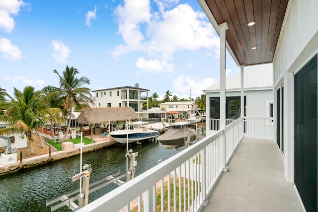 balcony featuring a water view, boat lift, and a boat dock