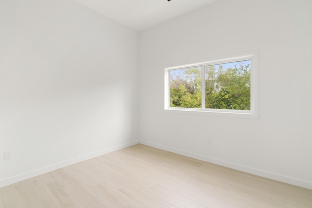 unfurnished room featuring baseboards and light wood finished floors